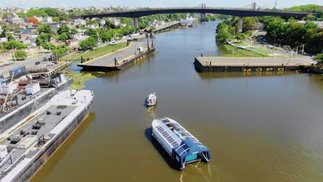 Abfangjäger-004-überquert-Das-Trübe-Wasser-Des-Ozama-Flusses,-In-Santo-Domingo,-Dominikanische-Republik,-Klarer-Tag,-Blauer-Himmel,-Schwimmende-Brücke,-Boot-Herum