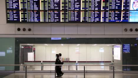 Pasajeros-Con-Máscaras-Faciales-Saliendo-De-La-Sala-De-Llegadas-En-La-Terminal-Del-Aeropuerto-Internacional-De-Hong-Kong