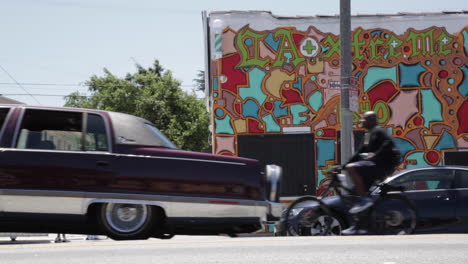 LA-Car-Show,-Purple-Cadillac-Brougham,-Lincoln-Town-Car,-Hydraulics,-Two-Wheels,-Fans-Filming-and-Having-Fun