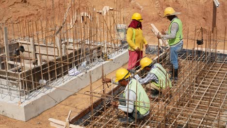 Bauarbeiter-Installieren---Fertigen-Holzschalungen-Und-Bewehrungsstäbe-Auf-Der-Baustelle