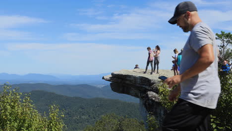 A-girl-posing-for-a-photo-with-her-dog-on-top-of-McAfee-Knob-in-Virginia