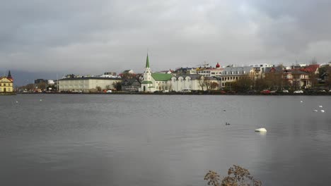 Busy-scene-in-Reykjavik,-Iceland,-panning-drone-shot-from-coastline