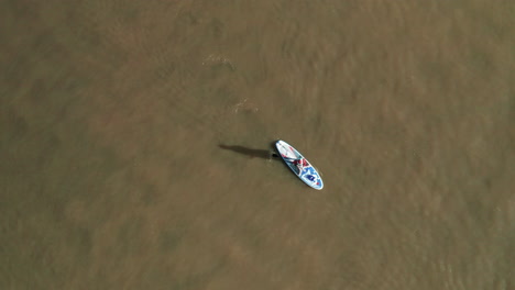 Lone-Person-Wearing-Santa-Claus-Costume-In-Stand-Up-Paddle-Board-At-Obidos-Lagoon,-Portugal