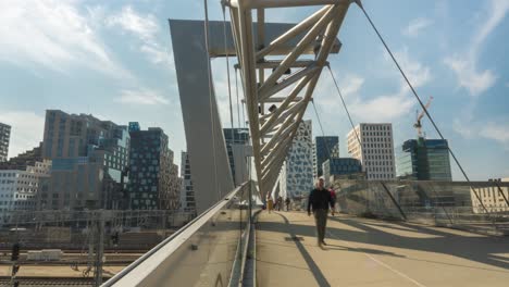 Time-lapse-of-people-walking-on-Oslo-Akrobaten-bru-pedestrian-bridge,-slide-view