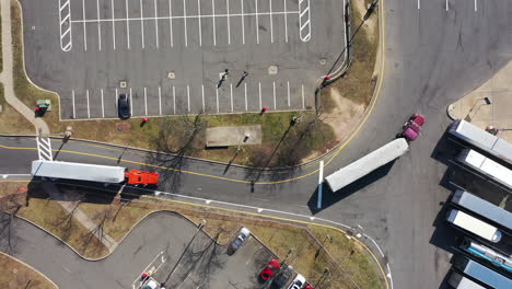 A-top-down-shot-over-two-trucks-pulling-in-to-a-truck-stop-on-a-sunny-day