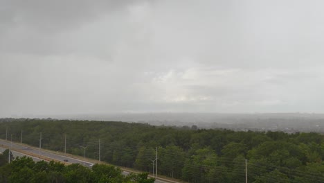Timelapse-sheet-rain-incoming-across-saturated-monsoon-woodland-highway-road