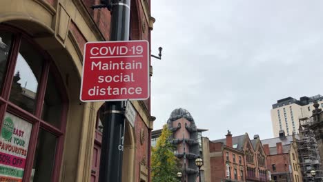 Coronavirus-warning-signs-in-Millennium-Square,-Leeds,-UK