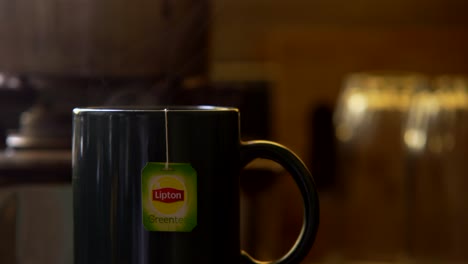 Bolsita-De-Té-Verde-Lipton-En-Una-Taza-De-Vapor-De-Agua-Caliente-Closeup