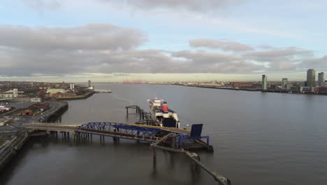 Stena-Line-logistics-ship-terminal-aerial-leaving-river-Mersey-harbour-Liverpool-city-landscape-rising-tilt-down