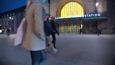 People-walking-in-front-of-the-Central-Railway-Station-in-Helsinki,-Finland