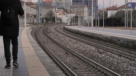 Rückansicht-Eines-Mannes,-Der-In-Der-Nähe-Der-Bahnschienen-Am-Bahnhof-Läuft