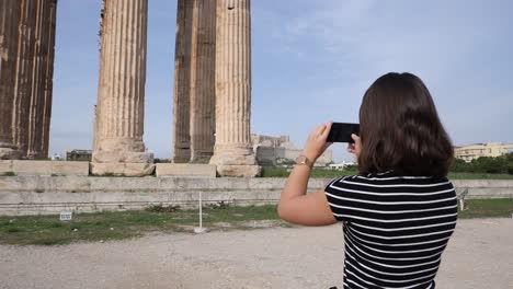 A-young-woman-is-filming-an-old-roman-building-with-her-smartphone