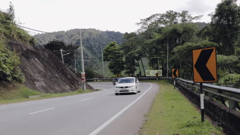 Coche-Blanco-Conduciendo-Cuesta-Arriba-Por-Un-Camino-Ventoso-En-Cameron-Highlands-Malasia