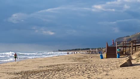 Menschen-Genießen-Einen-Ruhigen-Tag-Am-Strand,-Während-Die-Herbstzeit-Beginnt