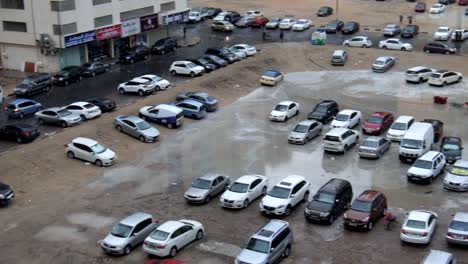 Flooded-sand-area-with-submerged-parked-cars-in-Al-Nahda,-Sharjah,-United-Arab-Emirates-after-heavy-rain-fall