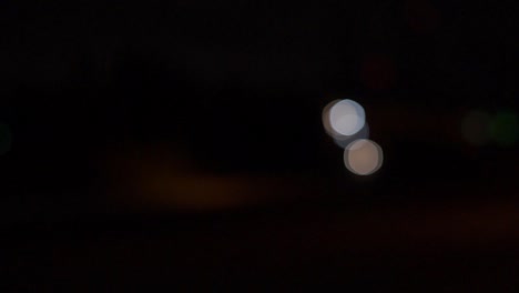 Car-headlights-out-of-focus,-bokeh-balls-moving,-night-time