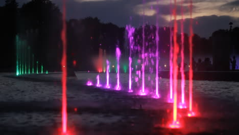 Eine-Lichtshow-Mit-Wasserspritzern-Im-Brunnen-Am-Spätsommerabend