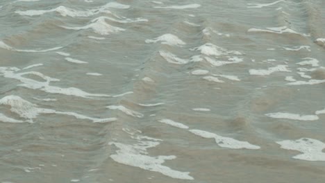 Wave-passing-by-with-white-foam,-Low-tide-water