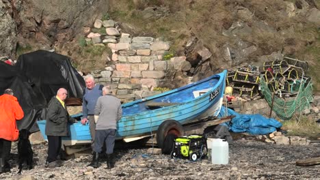 Cove-Bay-Hombre-Y-Perro-Se-Unen-A-Un-Grupo-De-Pescadores-Discutiendo-Un-Barco