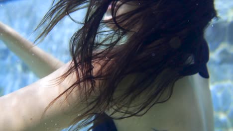 a-girl-is-swimming-underwater-in-a-pool