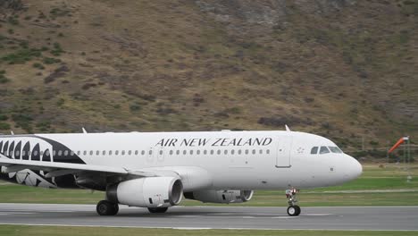 Slowmo---Verkehrsflugzeug,-Das-Vom-Flughafen-Queenstown,-Neuseeland,-Mit-Bergen-Im-Hintergrund-Abhebt