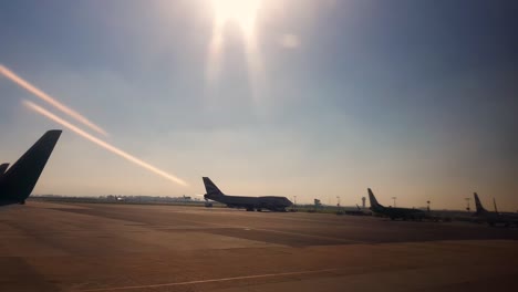 Malerischer-Blick-über-Die-Start--Und-Landebahn-Des-Flughafens-Mit-Teilweise-Silhouettierten-Flugzeugen,-Die-Zum-Start-Bereit-Sind