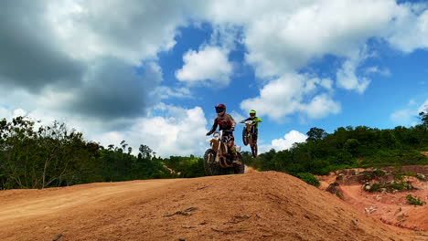 A-shot-of-men-riding-a-motorbike-on-dusty-red-racing-track-or-trail