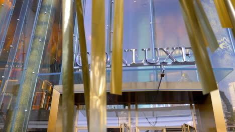 ICONLUXE-signage-above-front-entrance-doorway-to-Icon-Siam-luxury-shopping-mall-as-golden-ribbon-blow-in-breeze-in-front-of-shot