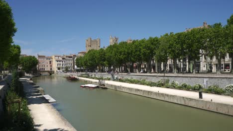 Narbonne,-view-along-the-Rhone-canal-of-the-historic-city-on-a-hot-sunny-day