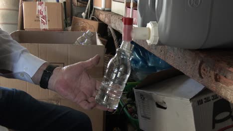 Filling-bottles-in-a-home-industry-with-chemicals-in-South-Africa,-close-up