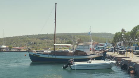Carvel-built-wooden-sailing-boat-moored-at-quite-Greek-village-harbor