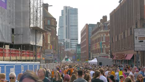 Leeds-Pride-LGBTQ-Festival-2019-Weitwinkelaufnahme-Mit-Der-Menge-Und-Pride-Flaggen-Und-Tanzenden-Köpfen,-Sonniges-Wetter-4k-25p