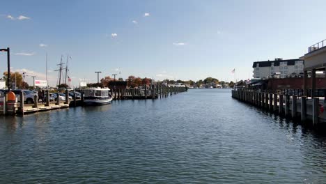 Boat-captain-point-of-view-dolly-shot-exiting-harbor-on-windy-autumn-day,-blue-water