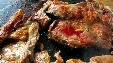 Blood-on-cow-chops-beef-steaks-grilled-seasoned-on-round-electric-griddle-closeup-zoom-alternative-green-cooking-kitchen-appliances-healthy-meal-cusine-garlic-herbs-spices-delicious-electricity-raw