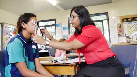 Auckland-Nueva-Zelanda-ópticos-Comprobando-La-Vista-De-Los-Niños-En-Edad-Escolar-En-La-Escuela-Primaria