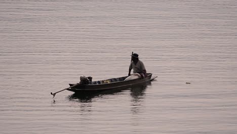 Fisherman-silhouetting-as-he-is-casting-and-drawing-his-net-in-the-River-before-dark