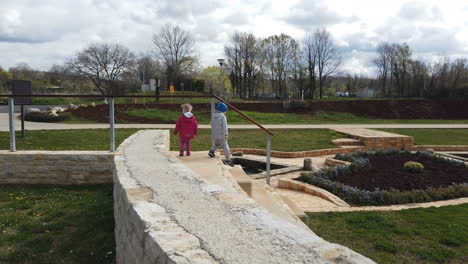 Zwei-Kleine-Kinder-Laufen-Entlang-Der-Treppe-Im-Park,-Bevor-Sie-Herunterkommen