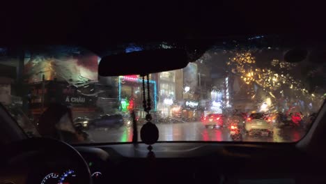 View-through-Taxi-window-in-pouring-tropical-rain-at-night-with-the-dazzling-lights-of-Ho-Chi-Minh-City-on-Saturday-night