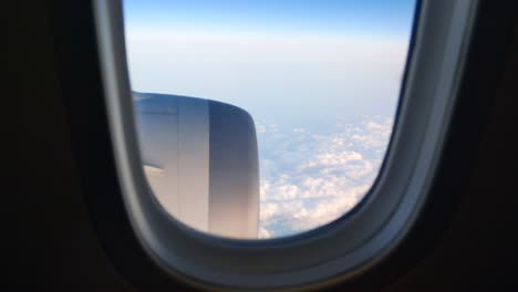 View-through-the-airplane's-cabin-window-see-the-engine-while-flying-on-35,000-feet-height-above-the-cloud-level-with-full-thrust-engine