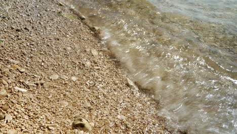 Close-up-of-many-waves-ending-on-the-pebble-beach-in-Croatia