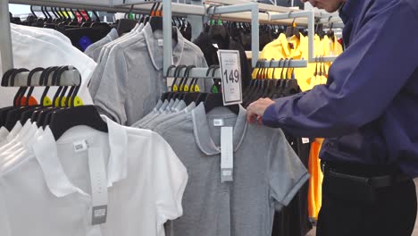 Young-Man-Choosing-Clothes-in-Store