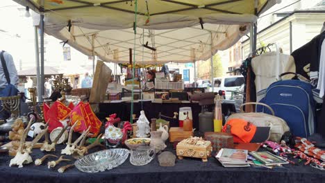 Table-with-goods-at-flea-market-in-Krakow-jewish-district,-Plac-Targowy-Unitard-Flea-Market,-Dolly-shot