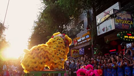 A-Golden-Dragon-jumping-and-dancing-in-the-middle-of-the-crowd-in-the-old-street-of-Phnom-Penh,-Cambodia-for-the-celebration-of-Chinese-New-Year---wide-shot