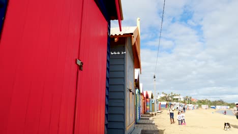 Tourists-walking-and-taking-photo-at-Brighton-Bathing-Boxes,-Melbourne,-Australia