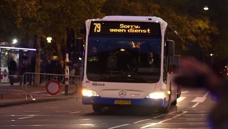 Policeman-Riding-A-Motorcycle-With-GVB-Bus-Service-Driving-On-The-Street-At-Night-During-The-Climate-Demonstration-From-The-Extinction-Rebellion-Group-At-Amsterdam,-Netherlands