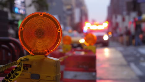 Close-up-of-a-caution-light,-with-flashing-ambulance-lights-in-the-background