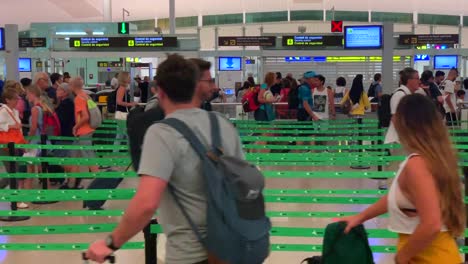 Interessante-Aufnahme-Von-Menschen,-Die-Am-Flughafen-Barcelona-Im-Zickzack-Durch-Die-Warteschlangen-In-Beide-Richtungen-Laufen-Und-Versuchen,-Durch-Die-Sicherheitskontrollen-Zu-Kommen,-Wobei-Menschen-Zu-Sehen-Sind,-Die-Während-Der-Fahrt-Zum-Flughafen-Eilen