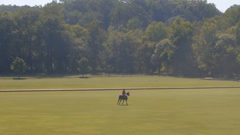 Atlanta,-Ga---21-De-Julio-De-2019:-Una-Toma-Amplia-Que-Muestra-Un-Exuberante-Campo-Verde-Con-Un-Jugador-De-Polo-Montando-Su-Caballo-Por-El-Campo-En-La-Distancia