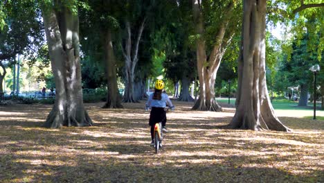 Jóvenes-Mujeres-Asiáticas-Montando-Citybike-Entre-árboles-En-Brisbane-Cbd-Botanic-Garden,-Ayuntamiento-De-Brisbane