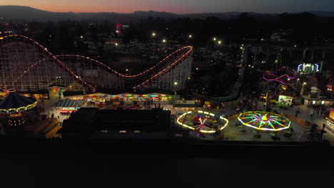 Aerial-Slide-Along-Full-Length-of-Amusement-Park-at-Night